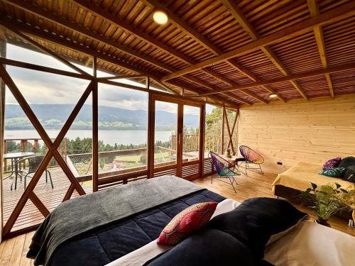 a room with a bed and a large window at Neusa Hills Glamping in Tausa Viejo