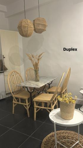 a dining table with chairs and a table with a vase at Sainte Apartments in Marseille