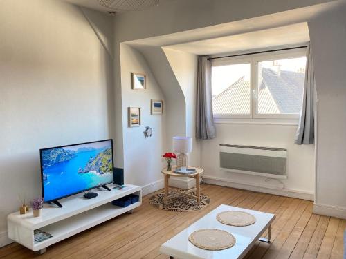 un salon avec une télévision à écran plat et une fenêtre dans l'établissement Au cocon bleu, à Calais