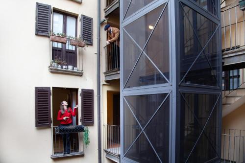 a woman looking out of a window of a building at RRRapido Home in Brera - Via Mercato in Milan