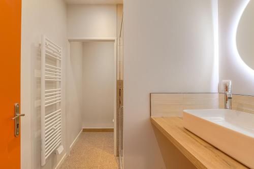 a bathroom with a white sink and a mirror at Lintemporel - travelhome in Villefranche-sur-Saône