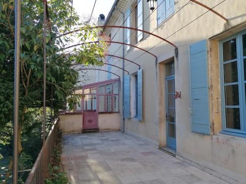 eine leere Gasse mit einer rosa Tür an einem Gebäude in der Unterkunft Croassecorbeau Maison de Famille au pied du Ventoux in Malaucène