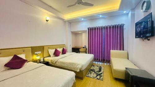 a hotel room with two beds and a purple curtain at Best Southern Hotel in Kuākāta