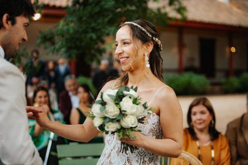 a bride is smiling as her groom gives her a bouquet at CASONA SAN PEDRO Hotel Boutique in San Javier
