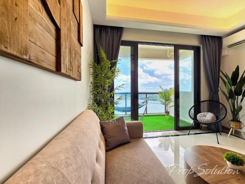 a living room with a couch and a view of the ocean at Cozy Seaview Suite Johor Bahru CIQ in Johor Bahru