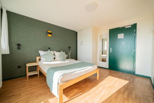 a bedroom with a bed with a green wall at Centre Jean XXIII in Annecy