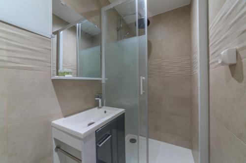 une salle de bain avec un lavabo blanc et une douche dans l'établissement Pasteur Collection - Cosy & Charmant 2pers, à Villeurbanne