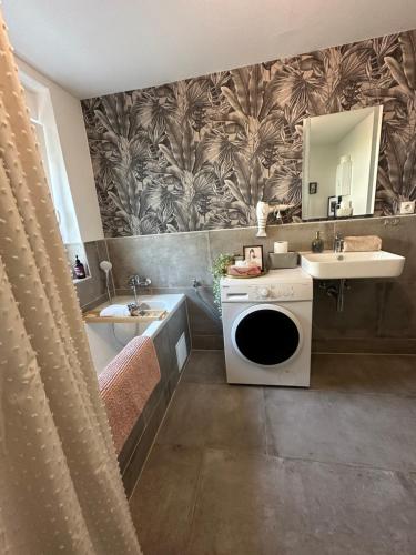 a bathroom with a sink and a washing machine at Stilvolles Apartment nähe Messe Düsseldorf in Duisburg Süd in Duisburg