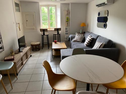 un salon avec un canapé et une table dans l'établissement Maison climatisée au centre du village, à Vogüé