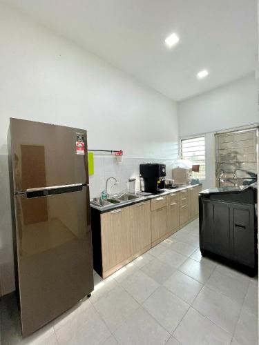 a kitchen with a stainless steel refrigerator and a sink at Kuala Selangor 93 in Kuala Selangor