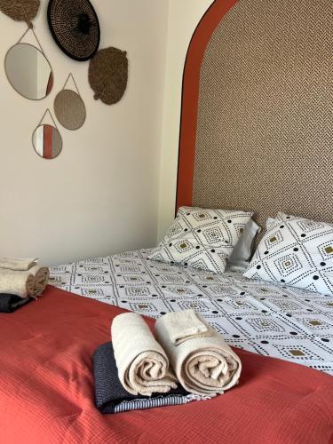 un lit avec deux serviettes et des oreillers dessus dans l'établissement Le p’tit bonheur-Piscine chauffée-clim-Park, à Carpentras