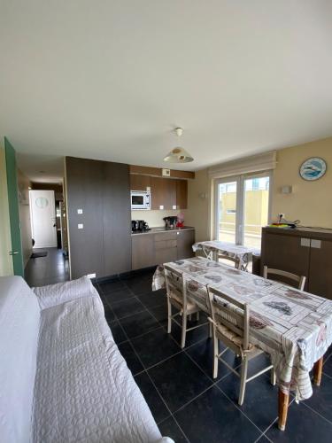 un salon avec une table et une cuisine dans l'établissement Vue mer Les Brisants Wimereux, à Wimereux