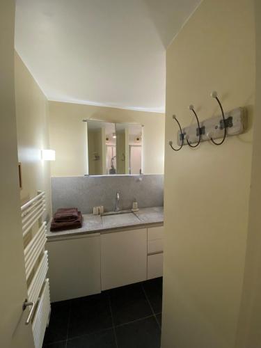 une salle de bain avec un lavabo et un miroir dans l'établissement Vue mer Les Brisants Wimereux, à Wimereux