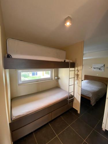 une petite chambre avec deux lits superposés et une fenêtre dans l'établissement Vue mer Les Brisants Wimereux, à Wimereux