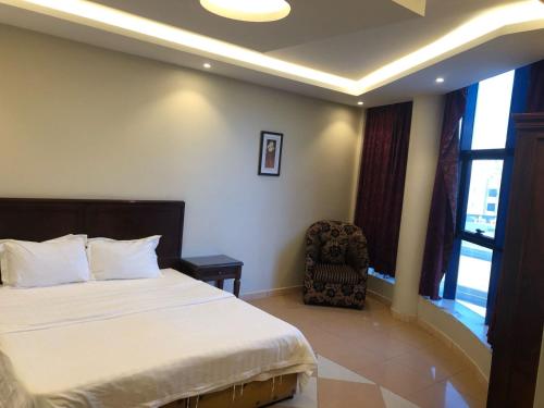 a hotel room with a bed and a chair at شقق أروع القصور للشقق المخدومة in Abha
