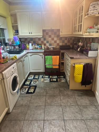 a kitchen with a washer and dryer on the floor at A beautiful tranquil home in Birmingham