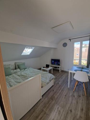 une chambre avec un lit et un bureau dans l'établissement Cosy F2 à Argenteuil Idéal séjour pro ou détente, à Argenteuil