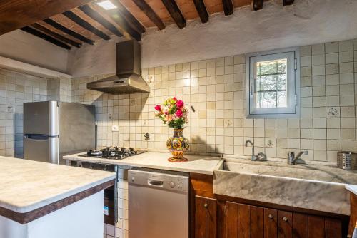 una cucina con lavandino e vaso di fiori di Green apartment Siena a Siena