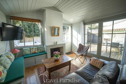 un salon avec un canapé et une cheminée dans l'établissement Villa Green Oaks, à Rivedoux-Plage