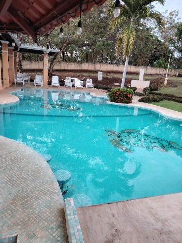a swimming pool with blue water in a resort at Villa jr 2 Cerca del Peñon de Guacalillo, tarcoles in Tivives