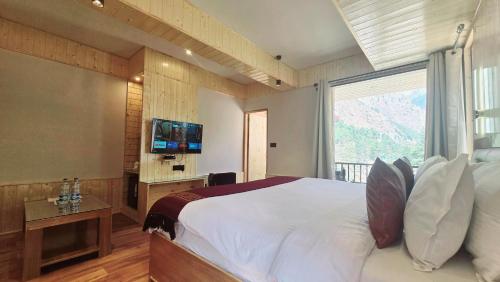 a bedroom with a large bed with a large window at The Hillside in Kasol