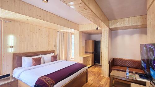 a bedroom with a large bed and a table at The Hillside in Kasol