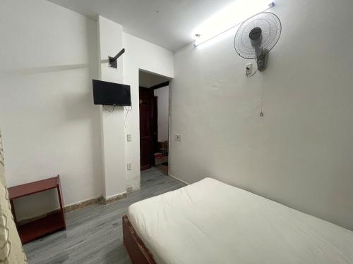 a white room with a bed and a fan at Bảo Trân Boutique Motel gần Sân Bay Và Trung Tâm in Da Nang