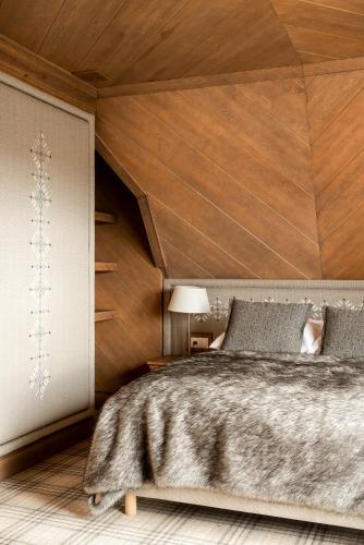 a bedroom with a bed and a wooden wall at Willa na Kozińcu in Zakopane