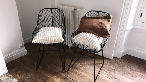two black chairs sitting next to a radiator at KastellRen - Rennes - Grand parking privé in Rennes
