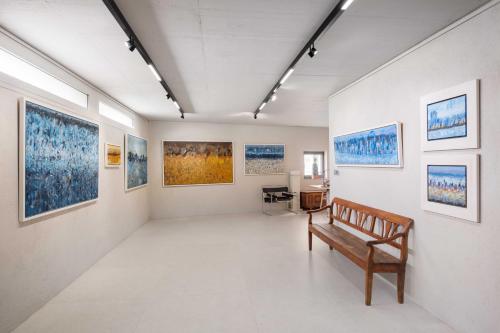 a room with a bench and paintings on the walls at Villa Artes with Free Hot Tub & Sauna in Branik