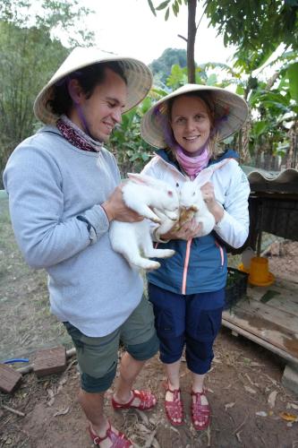 a man and woman wearing hats holding a cat at Phong Nha Magic Fingers Homestay and Spa in Phong Nha