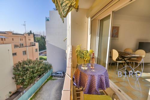 un balcon avec une table et une table à manger dans l'établissement Walking distance from the old town and the sea, à Antibes