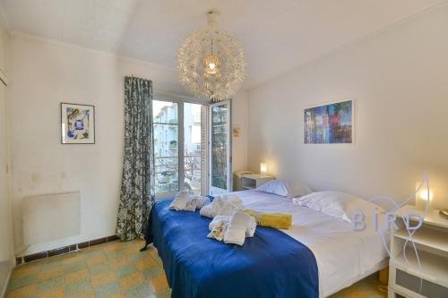 - une chambre dotée d'un lit avec des draps bleus et un lustre dans l'établissement Walking distance from the old town and the sea, à Antibes