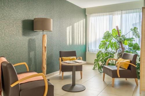 a living room with chairs and a table and a plant at Centre Jean XXIII in Annecy