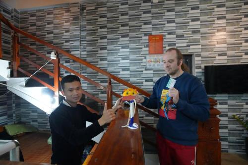 two men standing around a table with a toy on it at Phong Nha Magic Fingers Homestay and Spa in Phong Nha