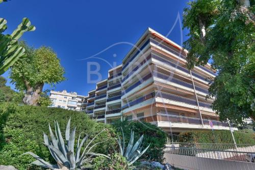 un grand immeuble avec des plantes devant lui dans l'établissement Vue Mer et Esterel Cannes just next to the beach, à Cannes