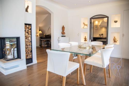 une salle à manger avec une table en verre et des chaises blanches dans l'établissement Belle maison familliale à Peymeinade 10 PAX, à Peymeinade