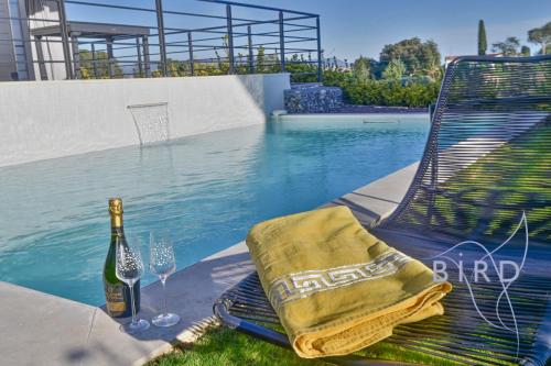 - une bouteille de champagne et deux verres à côté de la piscine dans l'établissement Contemporary Villa Pool and Sea View, à Cagnes-sur-Mer