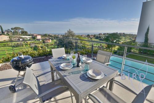une table et des chaises sur un balcon avec vue dans l'établissement Contemporary Villa Pool and Sea View, à Cagnes-sur-Mer