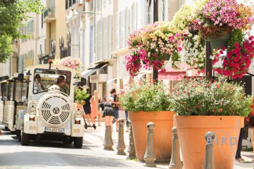 Une voiturette de golf qui descend dans une rue avec des fleurs à l'entrée. dans l'établissement Beautiful authentic apartment in the heart of old Antibes, à Antibes