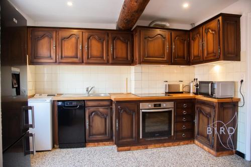 une cuisine avec des armoires en bois et un appareil noir dans l'établissement Beautiful authentic apartment in the heart of old Antibes, à Antibes