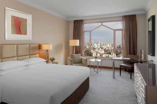 a hotel room with a bed and a large window at Grand Hyatt Amman in Amman