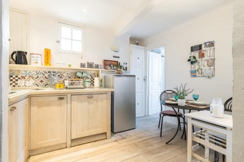 une cuisine avec un réfrigérateur en acier inoxydable et une table dans l'établissement Atypical apartment old town in Cannes large terrace, à Cannes