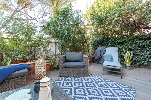 une terrasse avec des chaises en osier et un tapis bleu dans l'établissement Atypical apartment old town in Cannes large terrace, à Cannes