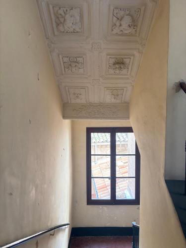 un couloir avec une fenêtre et un plafond dans l'établissement L Appart Aixois, à Aix-en-Provence