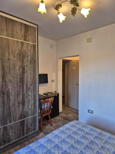 a bedroom with a wooden accent wall and a desk at K-Rooms in Veli Iž