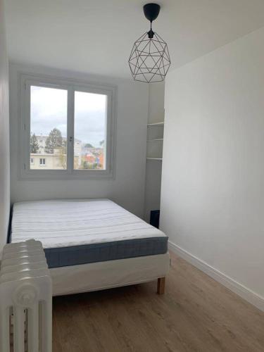 une chambre blanche avec un lit et une fenêtre dans l'établissement Lafont, à Nantes