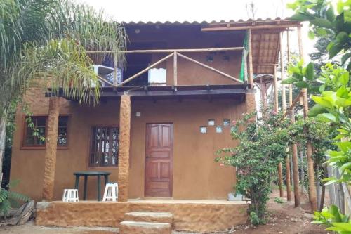 a house with two chairs in front of it at Chalé Aconchego in Santo Antônio do Leite