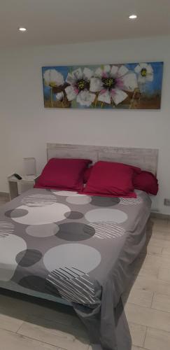 - un lit avec des oreillers rouges et un tableau mural dans l'établissement 4COMA2 - Appartement plein pied pour 4 personnes proche plage, à Collioure