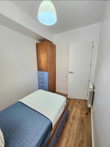 a small bedroom with a bed and a cabinet at Laxe Piso Sol - Wifi y Netflix in Laxe